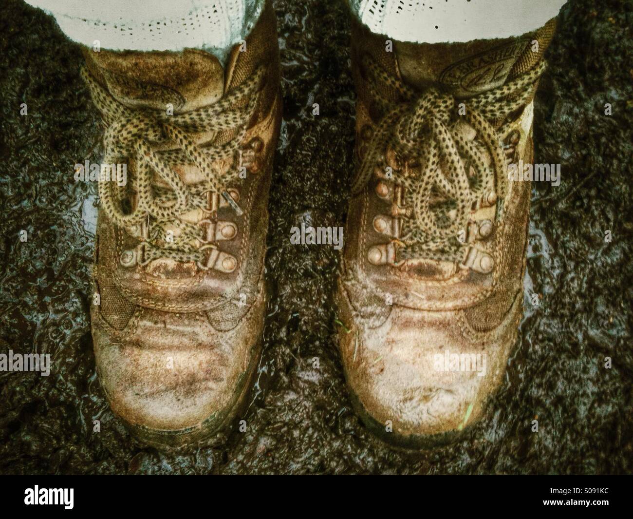 Muddy walking boots on a muddy footpath. - Smartphone Captured Stock Image
