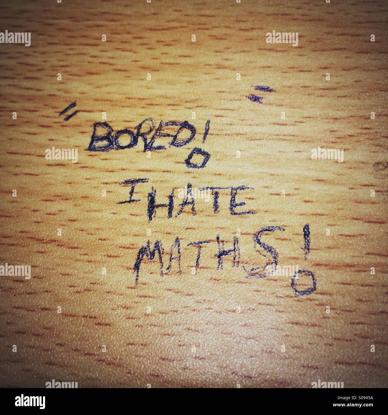 Bored I hate maths graffiti on a classroom table Stock Photo