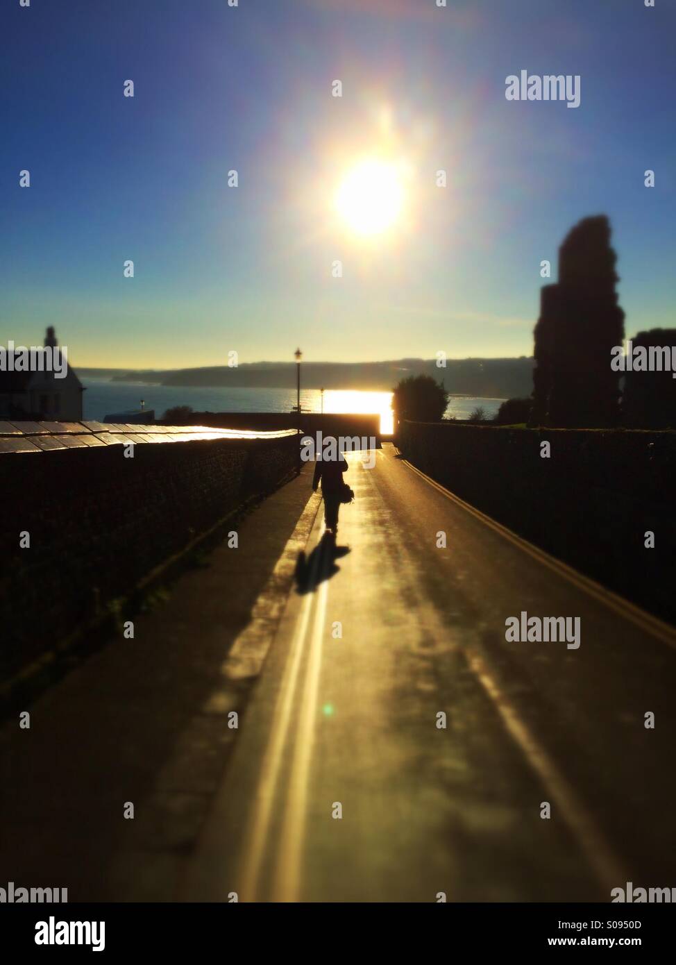 Woman walking into the sunset down a narrow street Scarborough North Yorkshire England UK - Smartphone Captured Stock Image