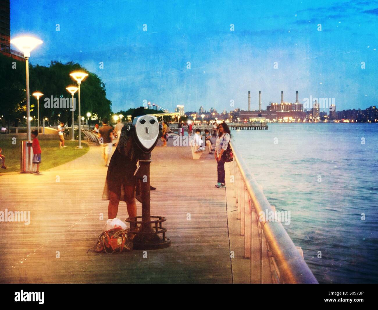 Gantry state park in Long Island City, promenade by the East river. Neighbors enjoying the fresh air in a summer night - Smartphone Captured Stock Image
