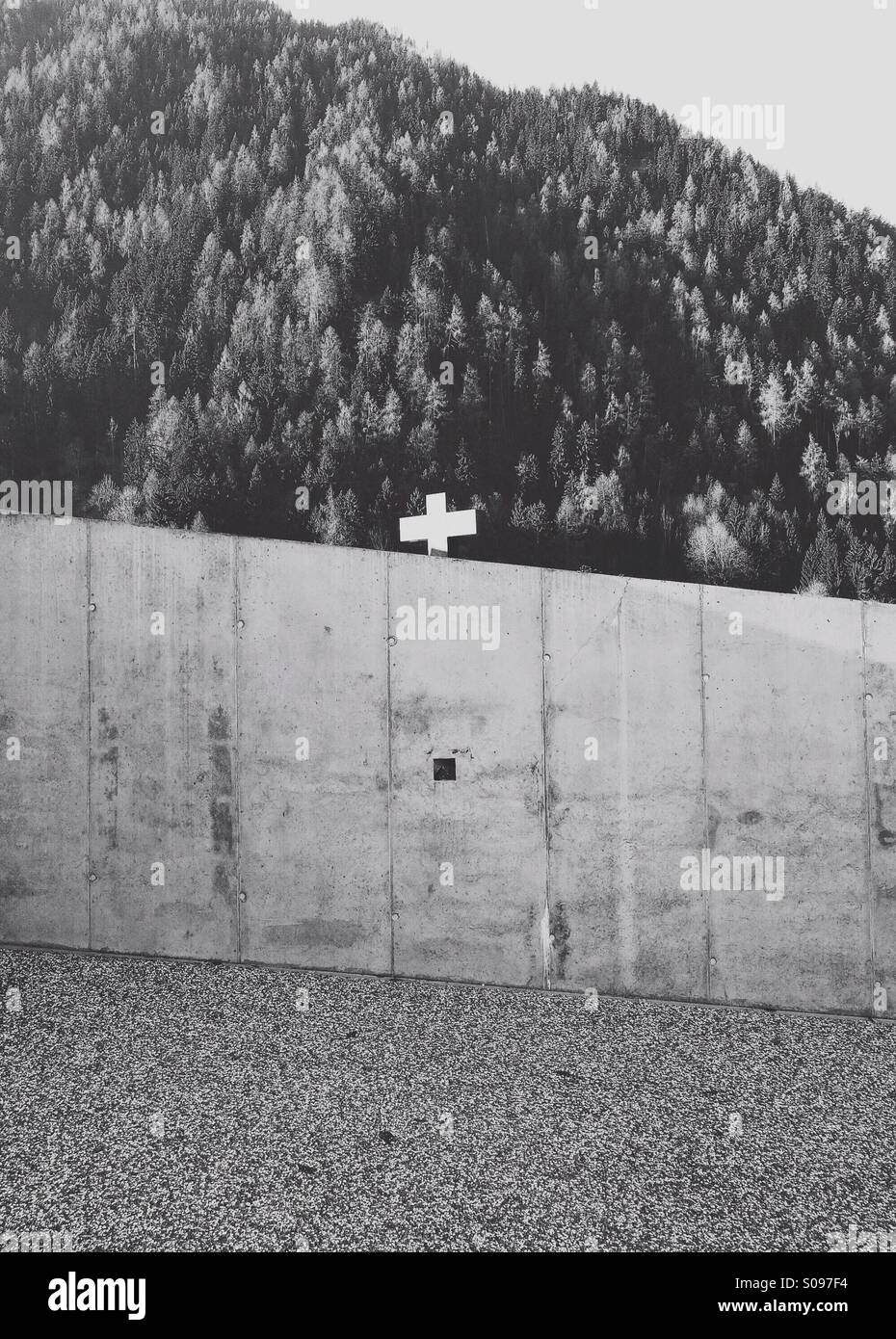 A crucifix cross hidden behind a modern concrete wall - Smartphone Captured Stock Image