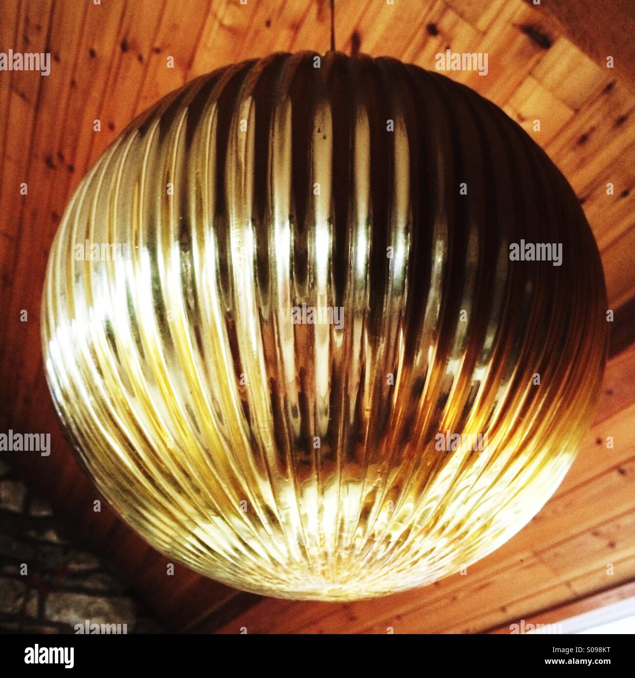 Giant gold bauble decoration hanging in a home. - Smartphone Captured Stock Image