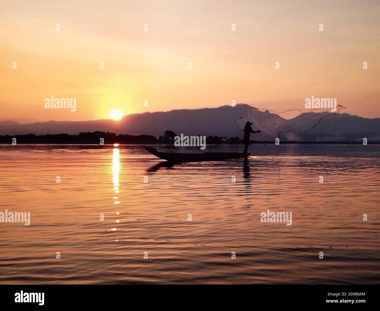 A true feeling of tranquility envelops the viewer as the sun sets across Kwan Phayao (Phayao Lake). Phayao, Thailand. Stock Photo