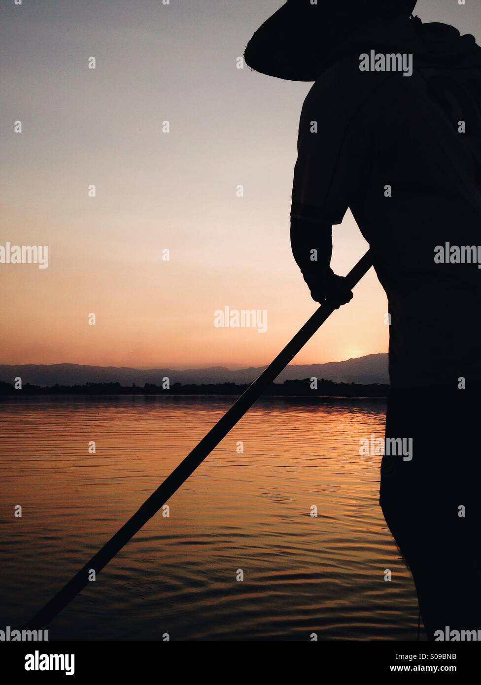 A silhouette finishing the day's fishing job on Kwan Phayao (Phayao Lake). Phayao, Thailand. Stock Photo