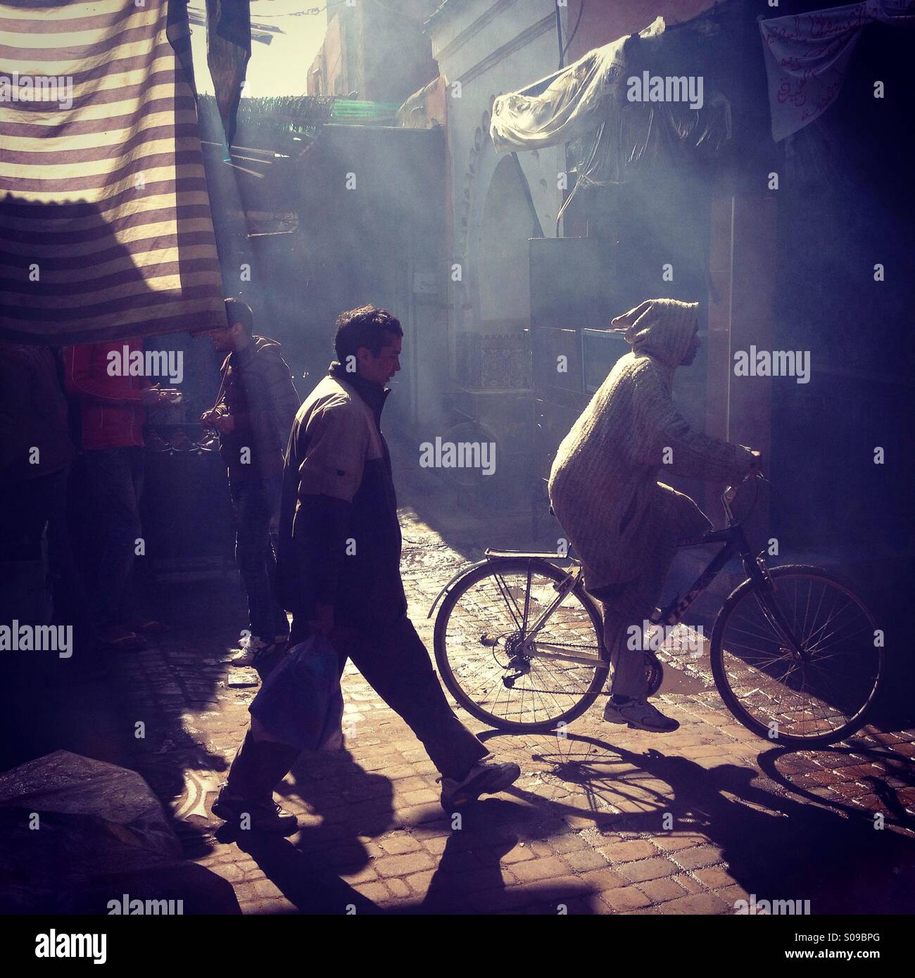 Men in the smoke and dust of the souk in Marrakech medina, Morocco. Stock Photo