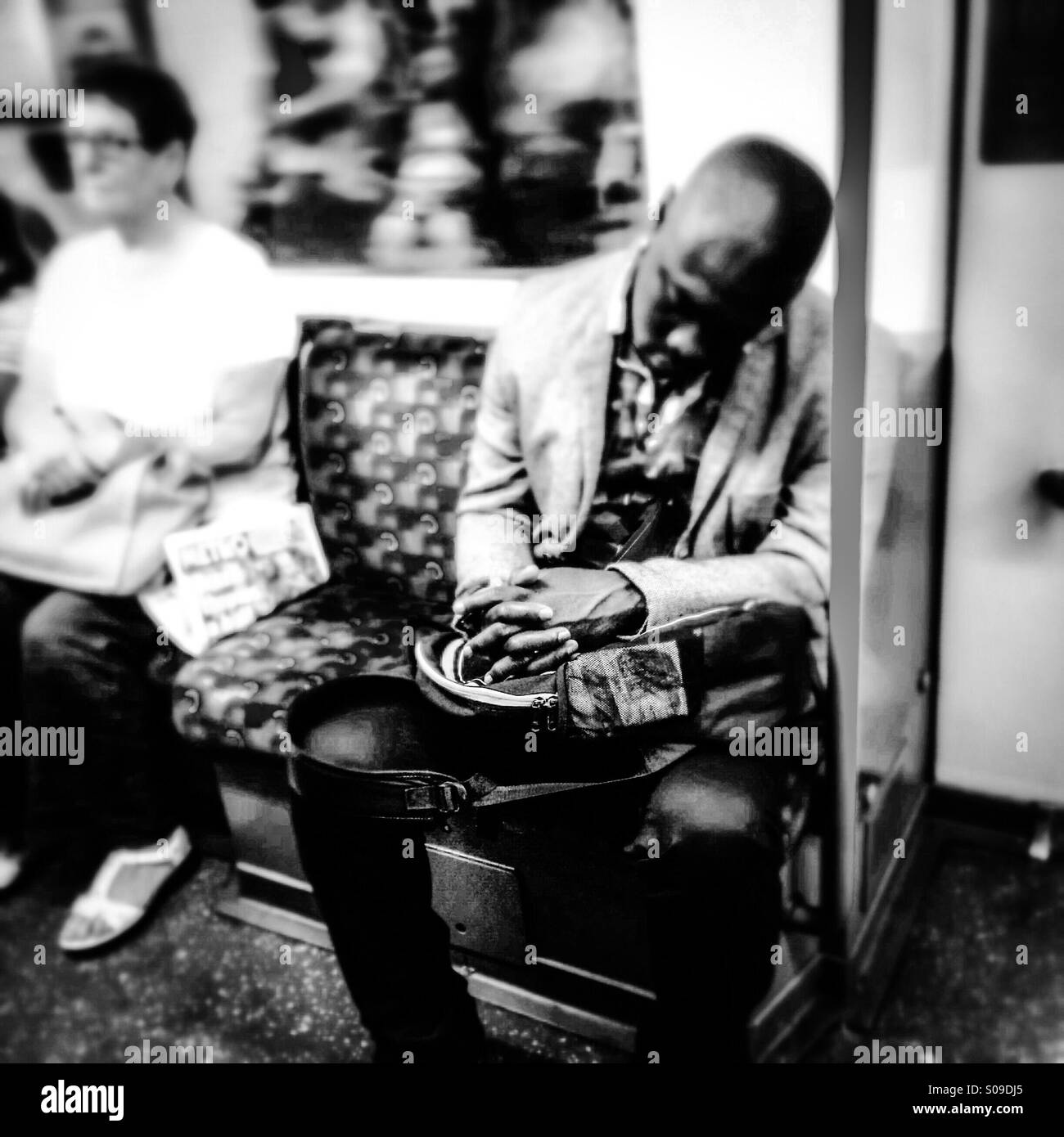 Man sleeps on London Underground Tube train Stock Photo