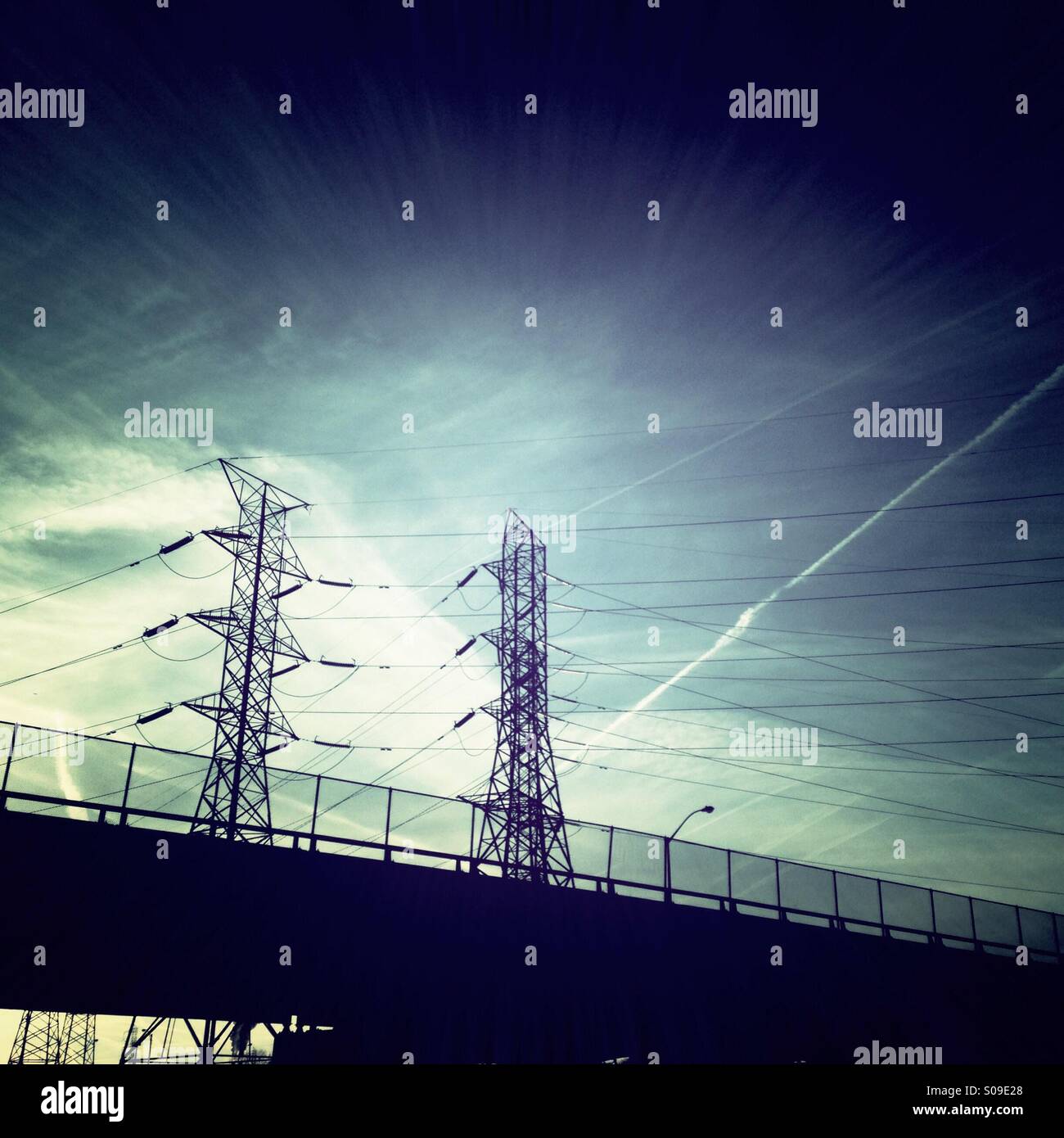 High tension power lines against a bright blue sky Stock Photo - Alamy