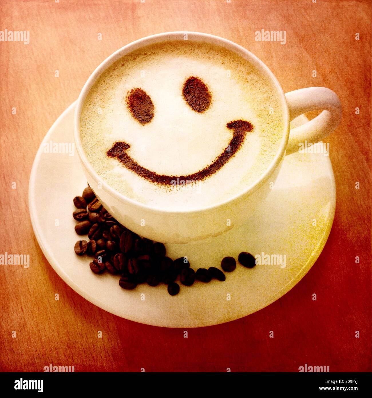 https://c8.alamy.com/comp/S09FYJ/a-warming-cup-of-hot-coffee-with-a-chocolate-powder-smiley-face-S09FYJ.jpg