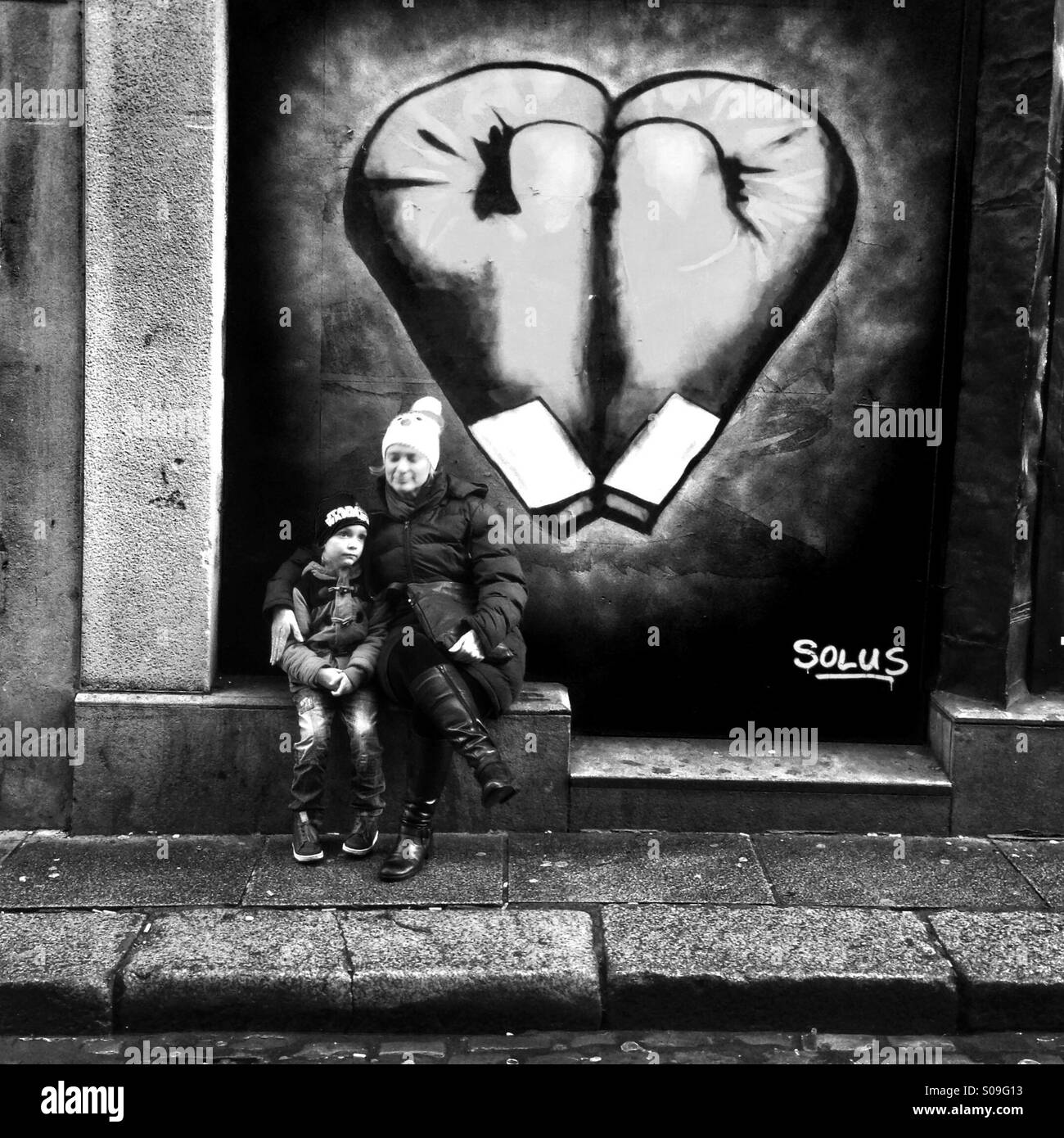 Mum & boy sit in front of graffiti in Dublin - Smartphone Captured Stock Image