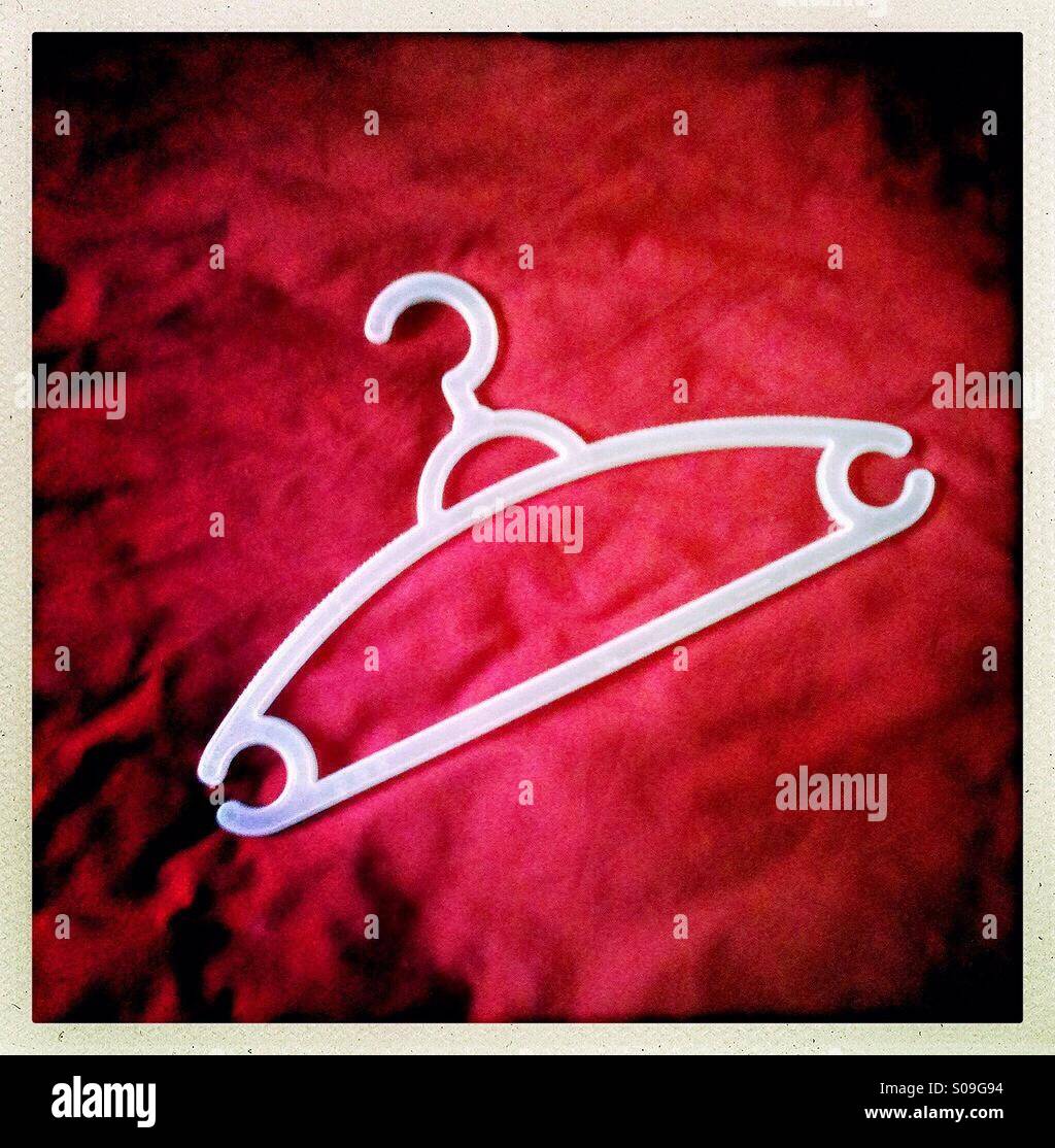 White clothes hanger on a red background Stock Photo