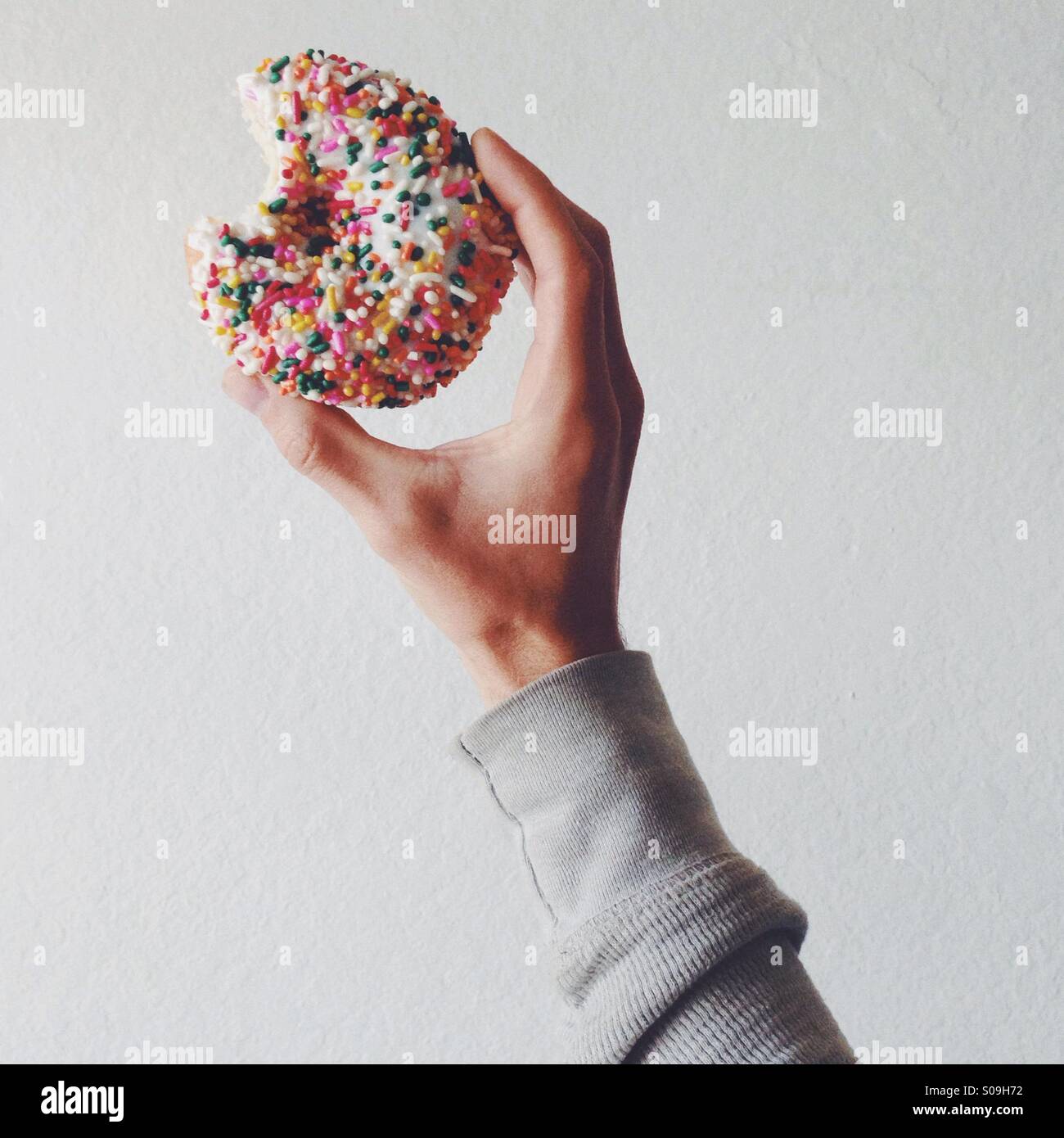 Holding a donut with sprinkles Stock Photo