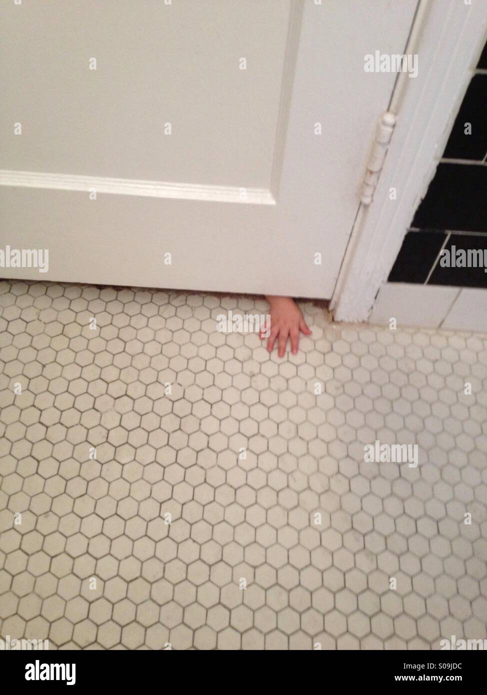 Child S Hand Reaching Under A Door Stock Photo 309998680