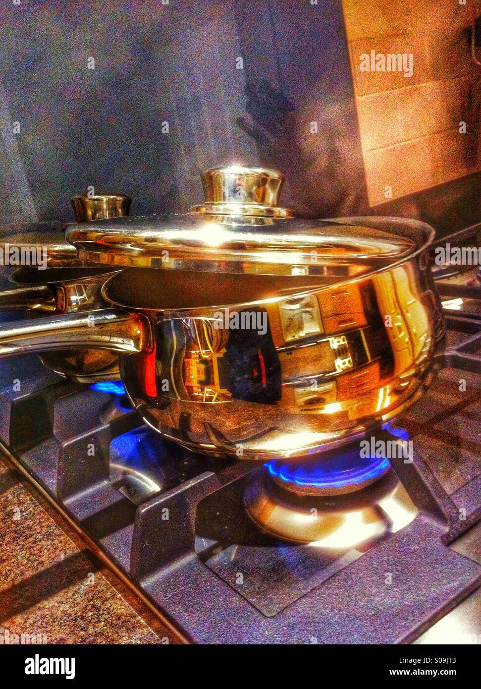 Stainless steel saucepans on gas hob Stock Photo Alamy