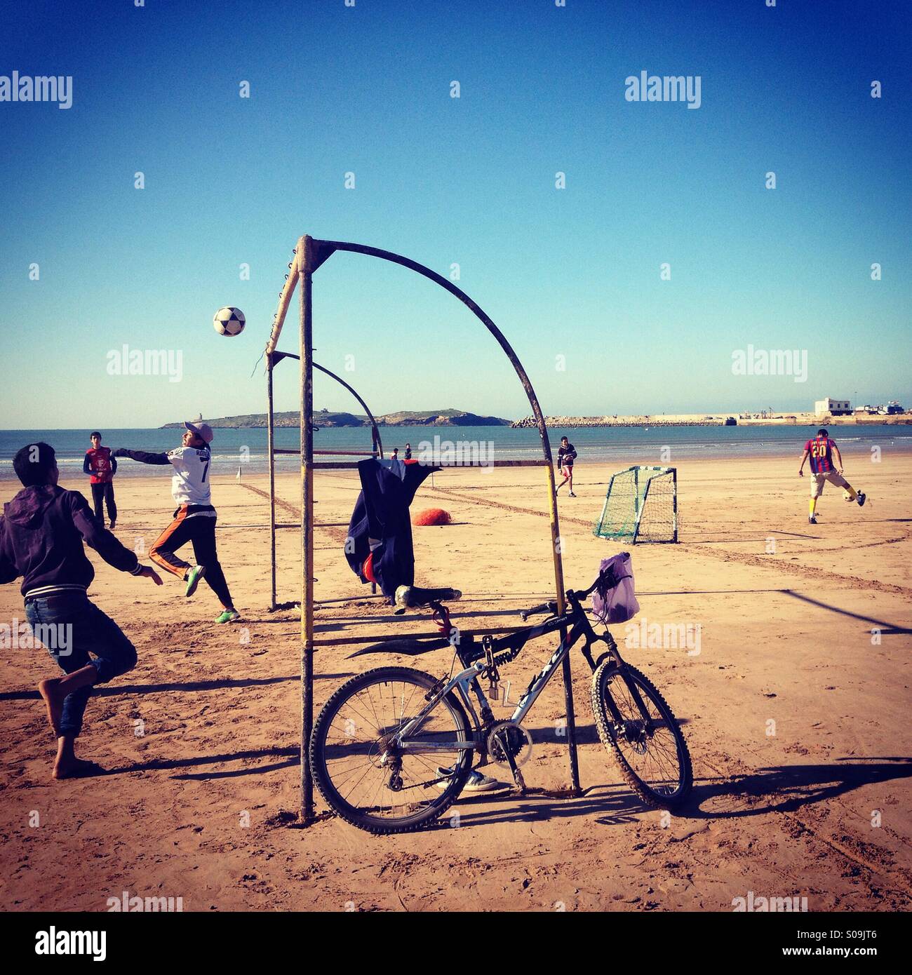 Playing football on the beach, Essaouira, Morocco. Stock Photo