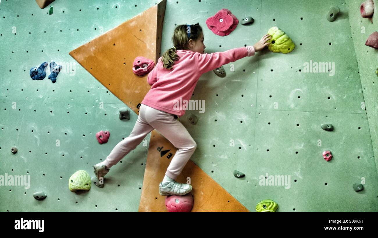 Eight year old girl climbing in bouldering room at indoor climbing centre. - Smartphone Captured Stock Image
