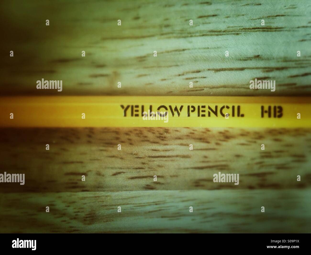 Yellow pencil with the words yellow pencil and HB on the side. Grunge effect applied. - Smartphone Captured Stock Image