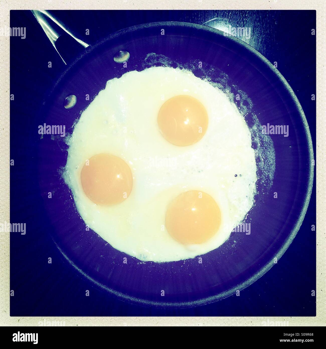 Three eggs frying in a pan - Smartphone Captured Stock Image