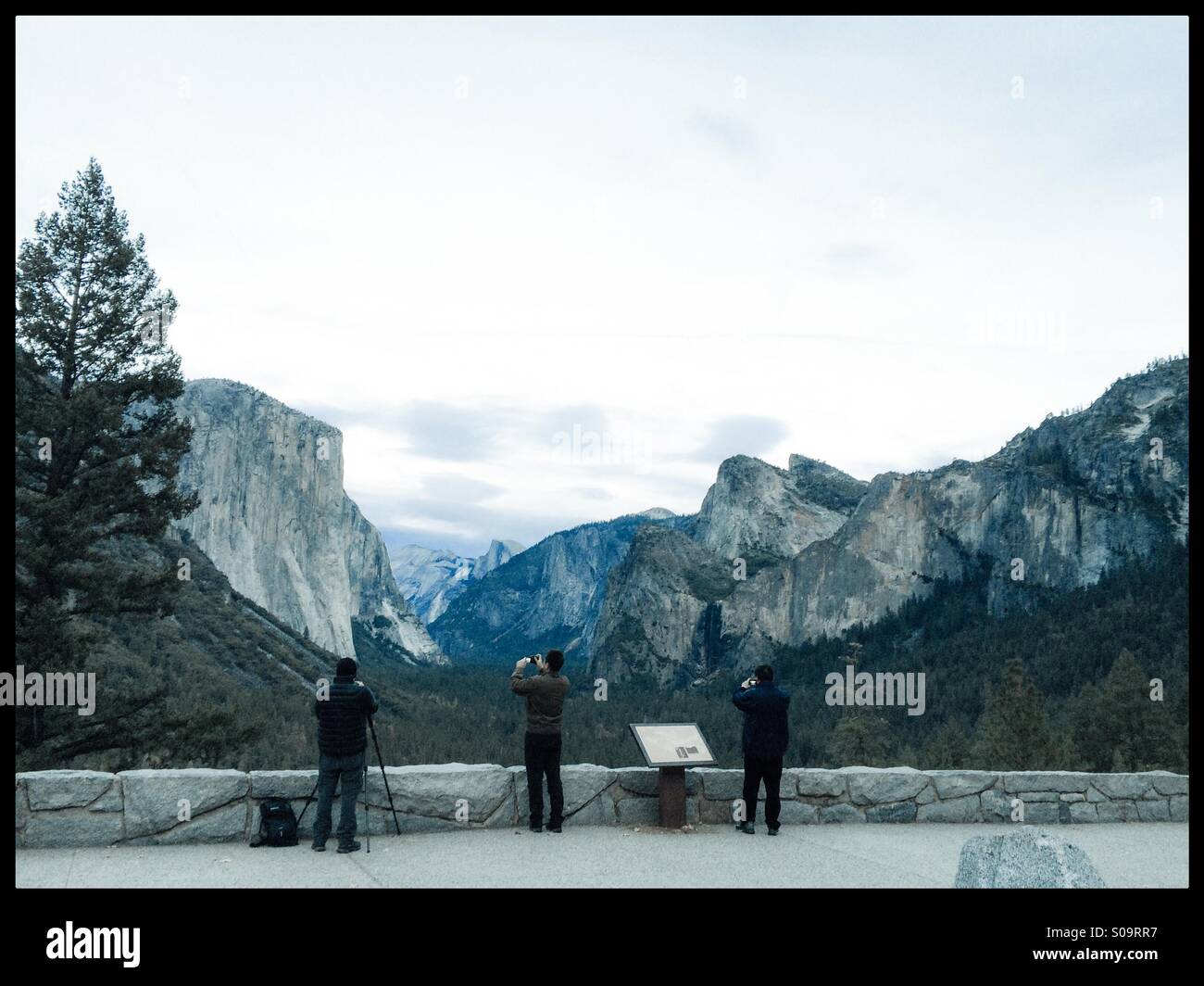 Three photographers take pictures at the famous Tunnel View vista on