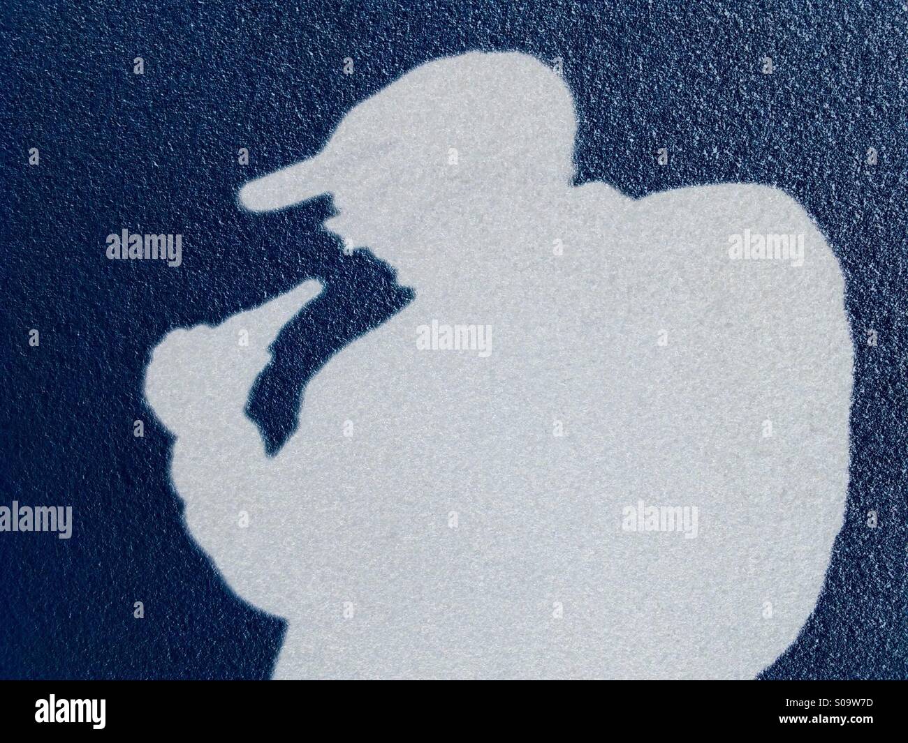 Shadow of a man wearing a baseball hat drinking from a bottle - Smartphone Captured Stock Image