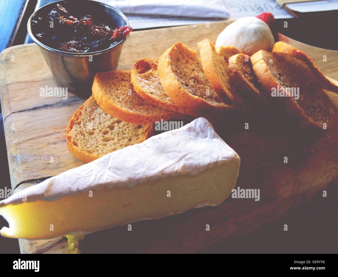 Cheese plate with Brie and goat cheese ball, with stacked toast points and a cranberry chutney. Stock Photo