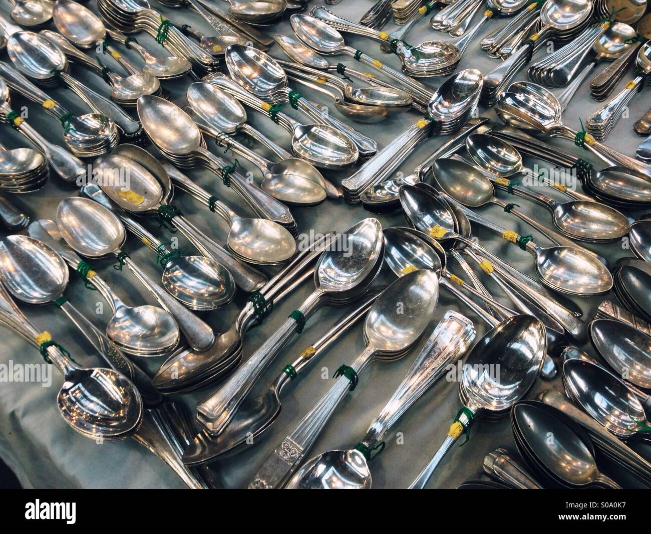 Silver spoons for sale at an antiques market Stock Photo
