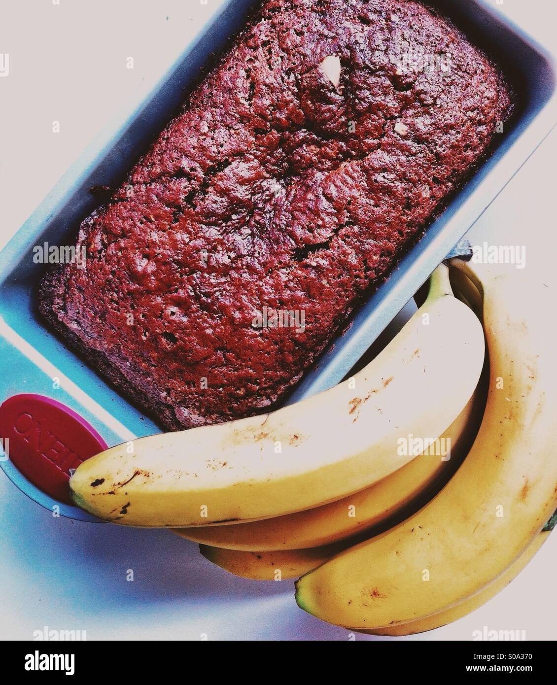 Vegan banana bread in the baking pan and bunch of bananas - Smartphone Captured Stock Image