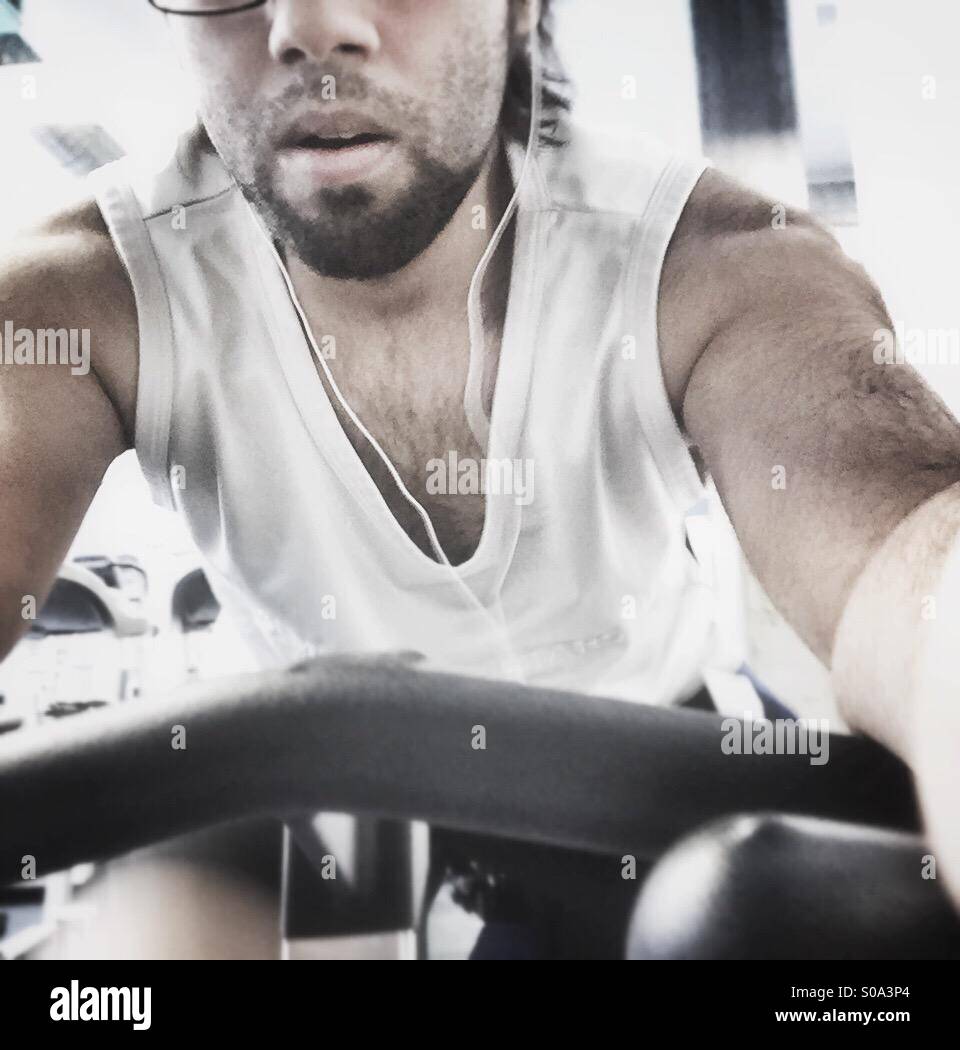 A guy at the gym on a stationary bike Stock Photo