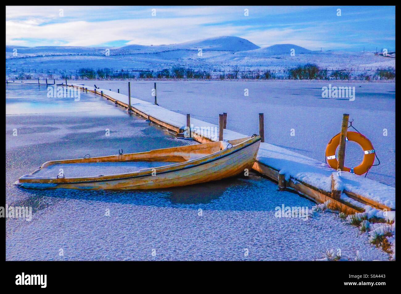 Fishing boat deep in water after a winter snow shower, Eaglesham moor, Glasgow, Scotland, UK - Smartphone Captured Stock Image