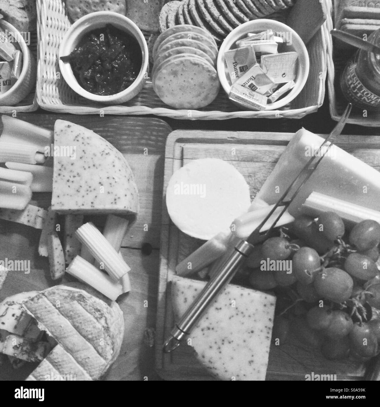 Black and white image of a cheese platter spread on a table - Smartphone Captured Stock Image