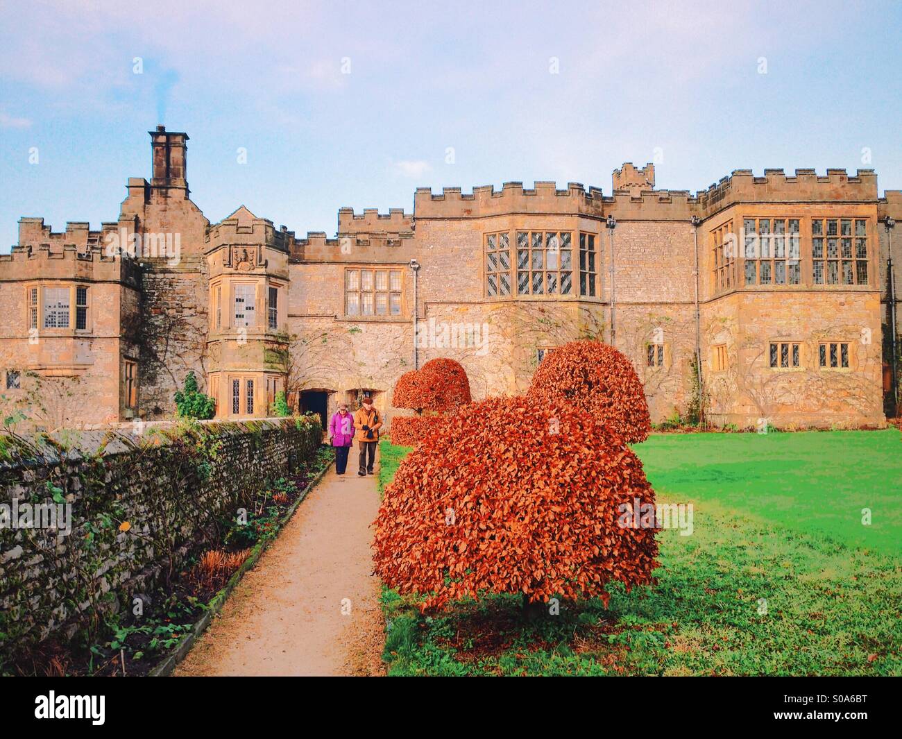 Two people walk through the gardens at Haddon Hall, Bakewell, Derbyshire, England. December 2014. Stock Photo