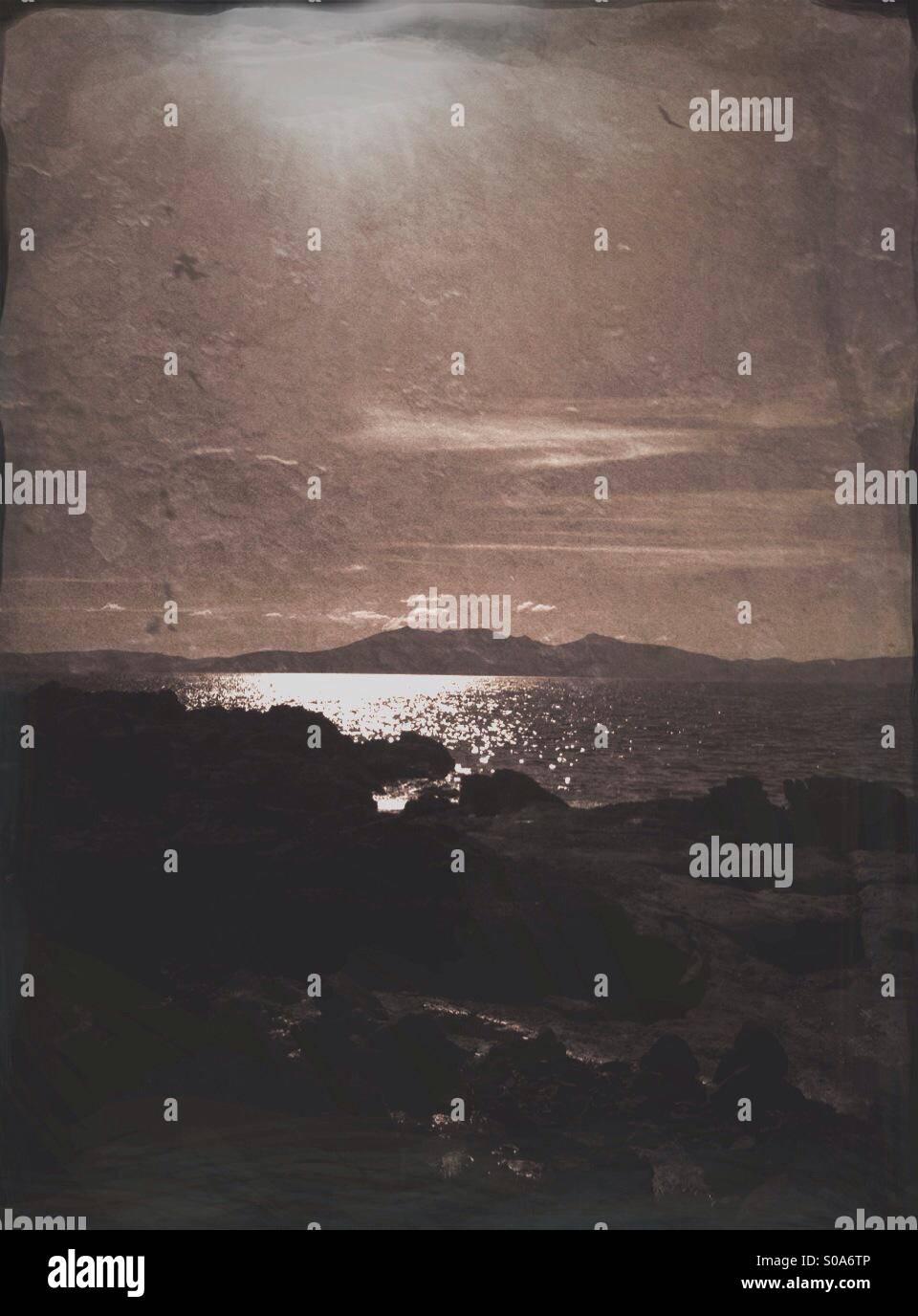 Textured moody shot of the Isle of Arran seen from rocky beach on the West Coast of Scotland. - Smartphone Captured Stock Image