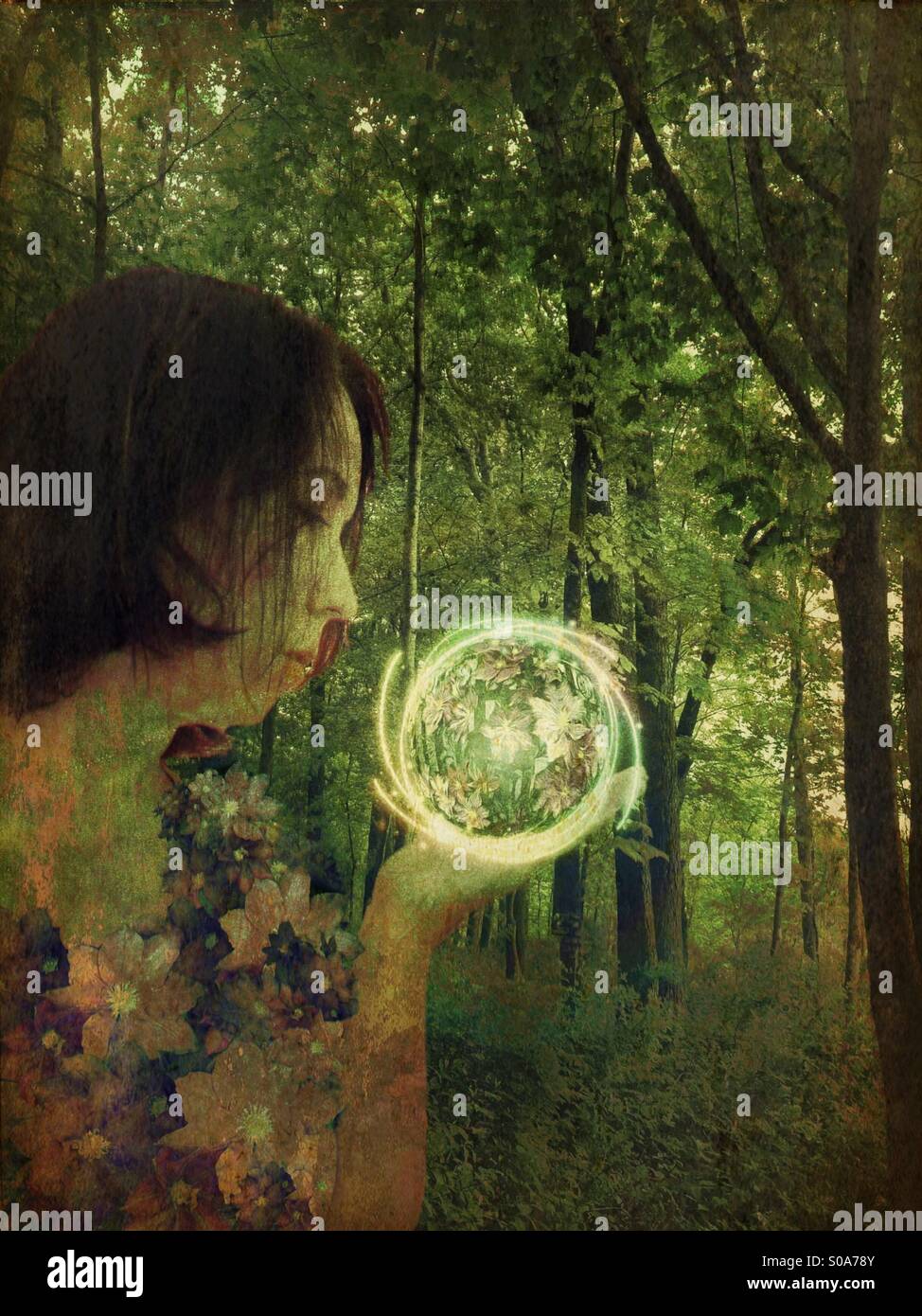 Woman in the woods holding a floral orb Stock Photo