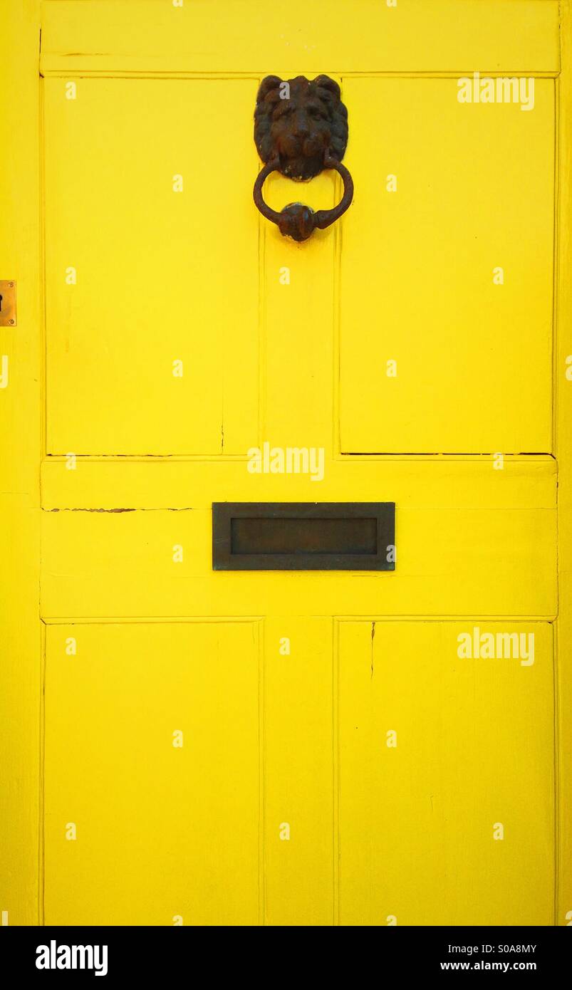A yellow door in Nottingham, England. With a lions head door knocker. Stock Photo