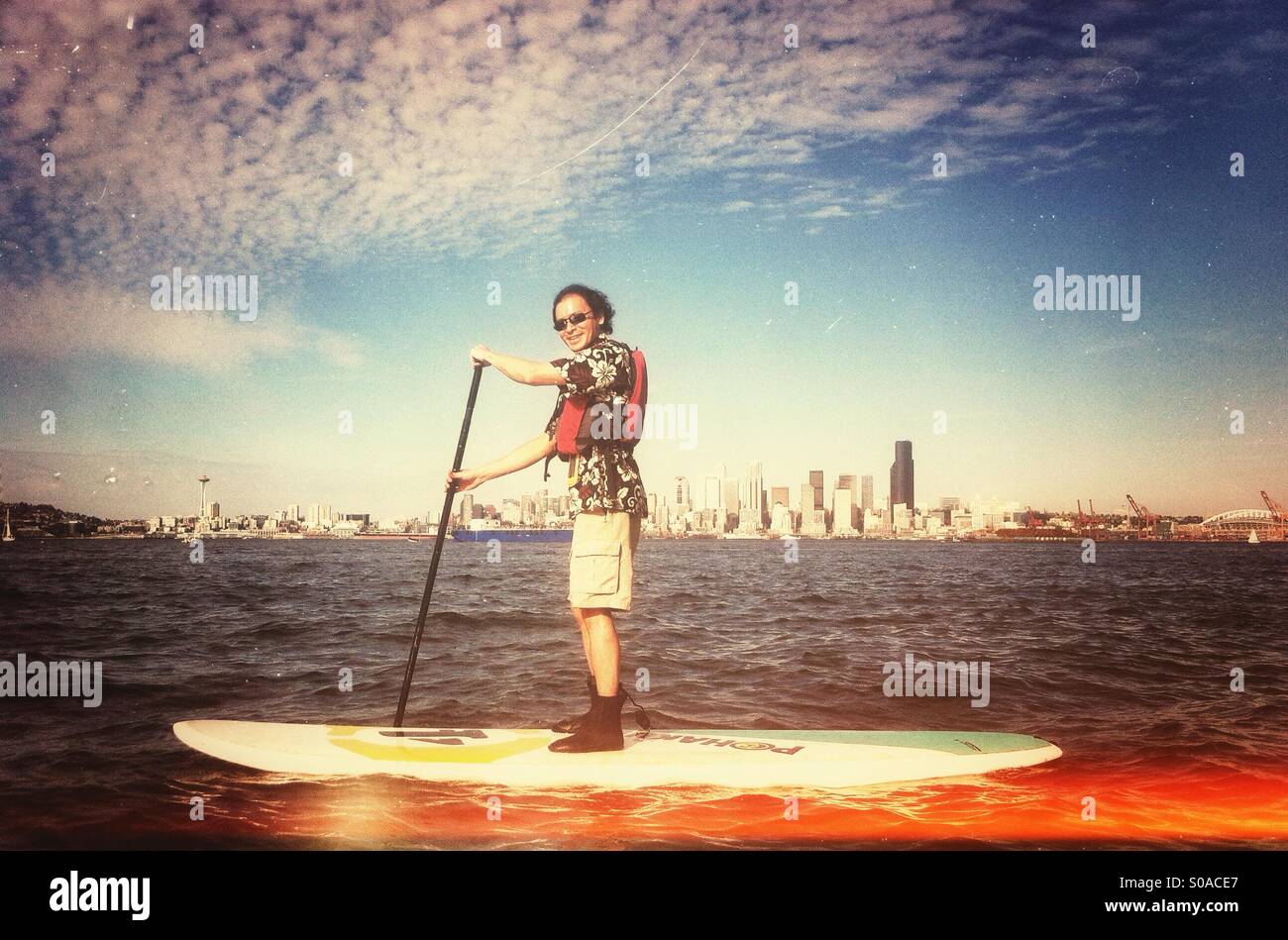 Man on paddle board in front of Seattle skyline Stock Photo