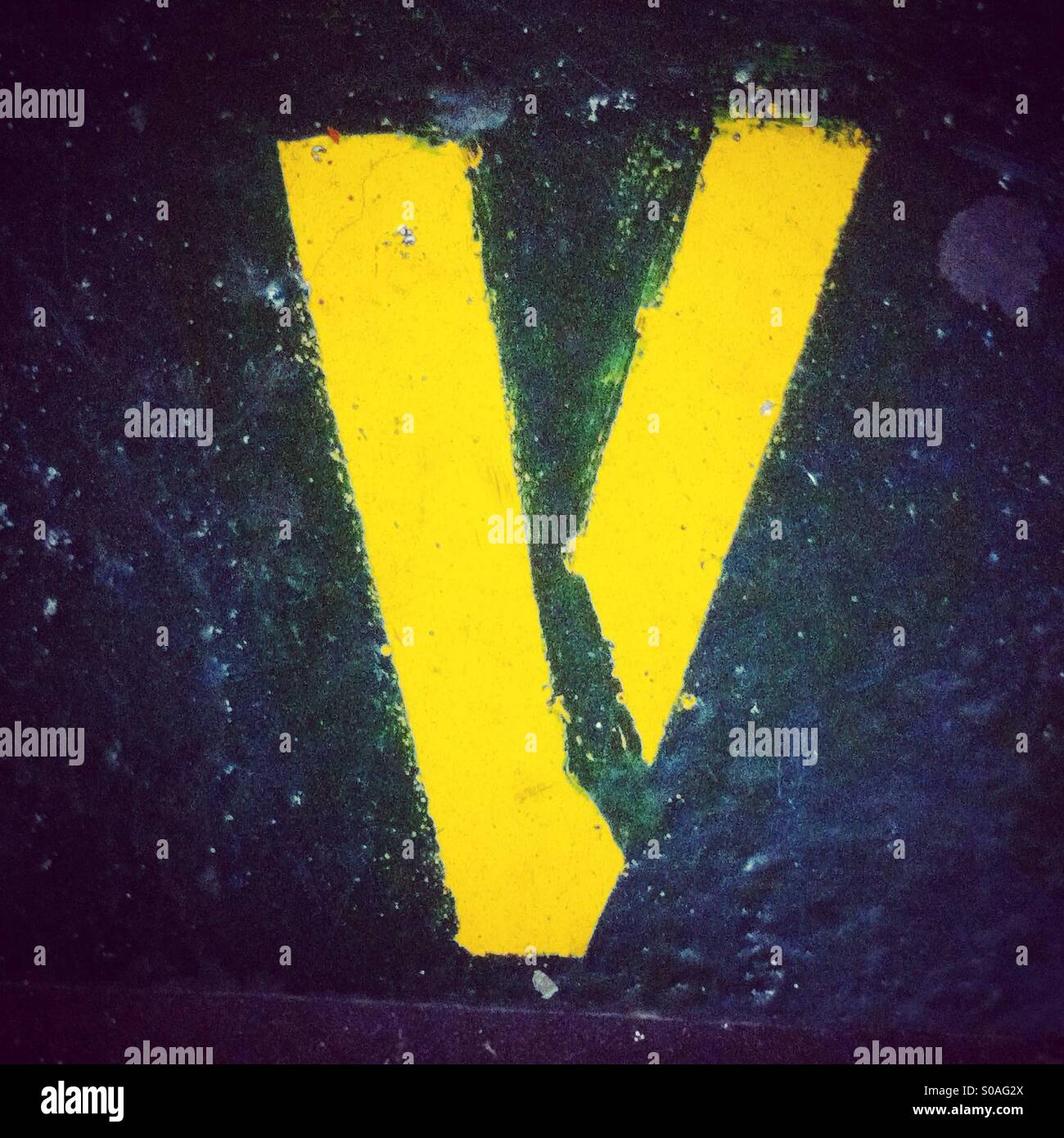 V letter painted in a stencil way in yellow color Stock Photo