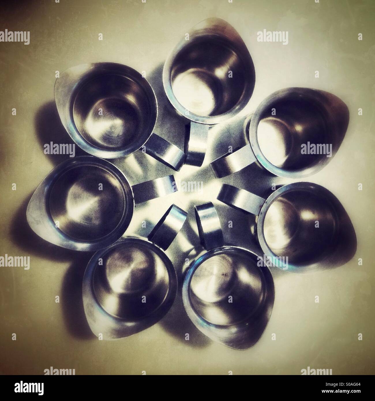 Seven small metal pitchers forming a flower shape - Smartphone Captured Stock Image