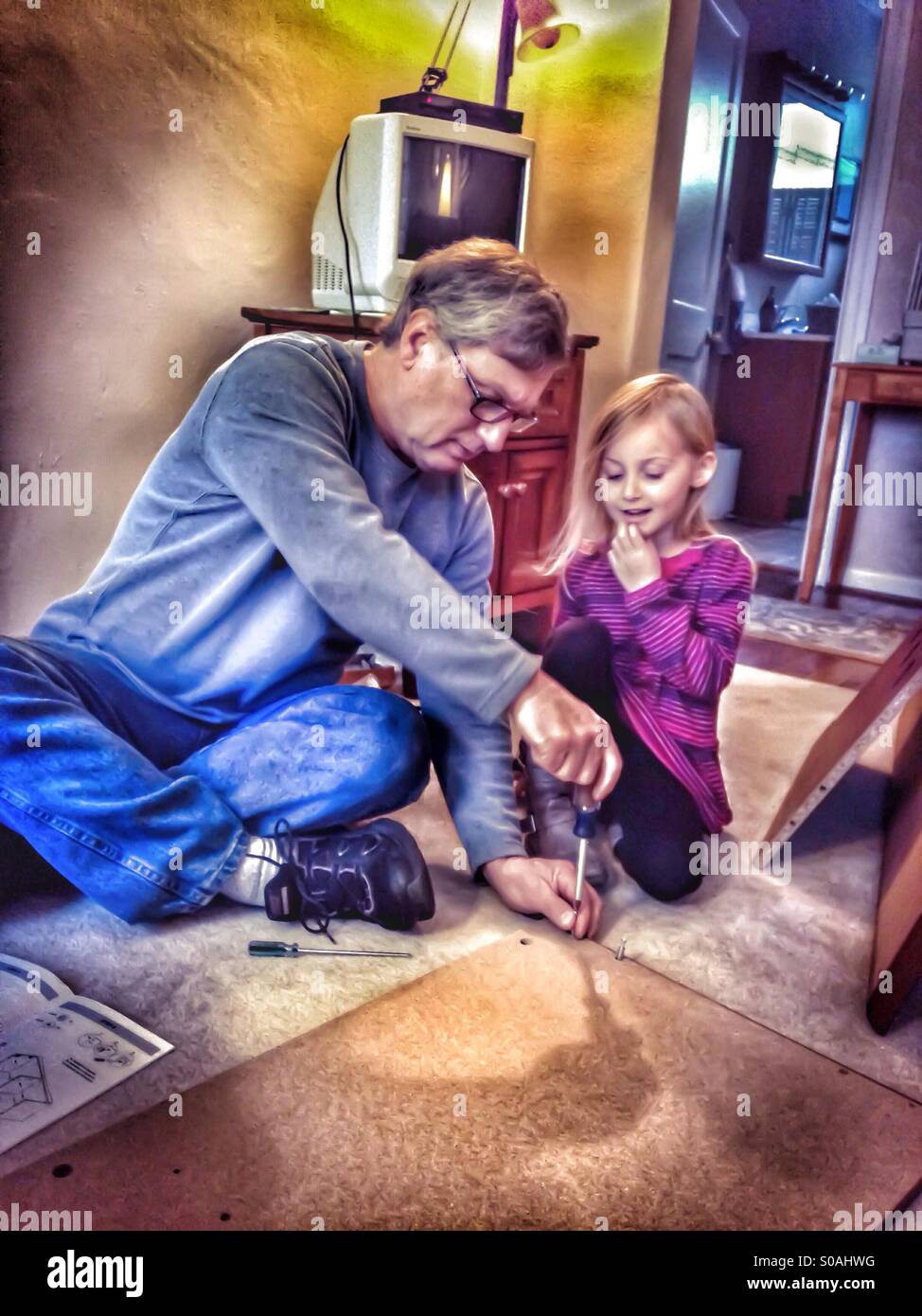 Child watches as grandpa uses tools (color/hdr). - Smartphone Captured Stock Image