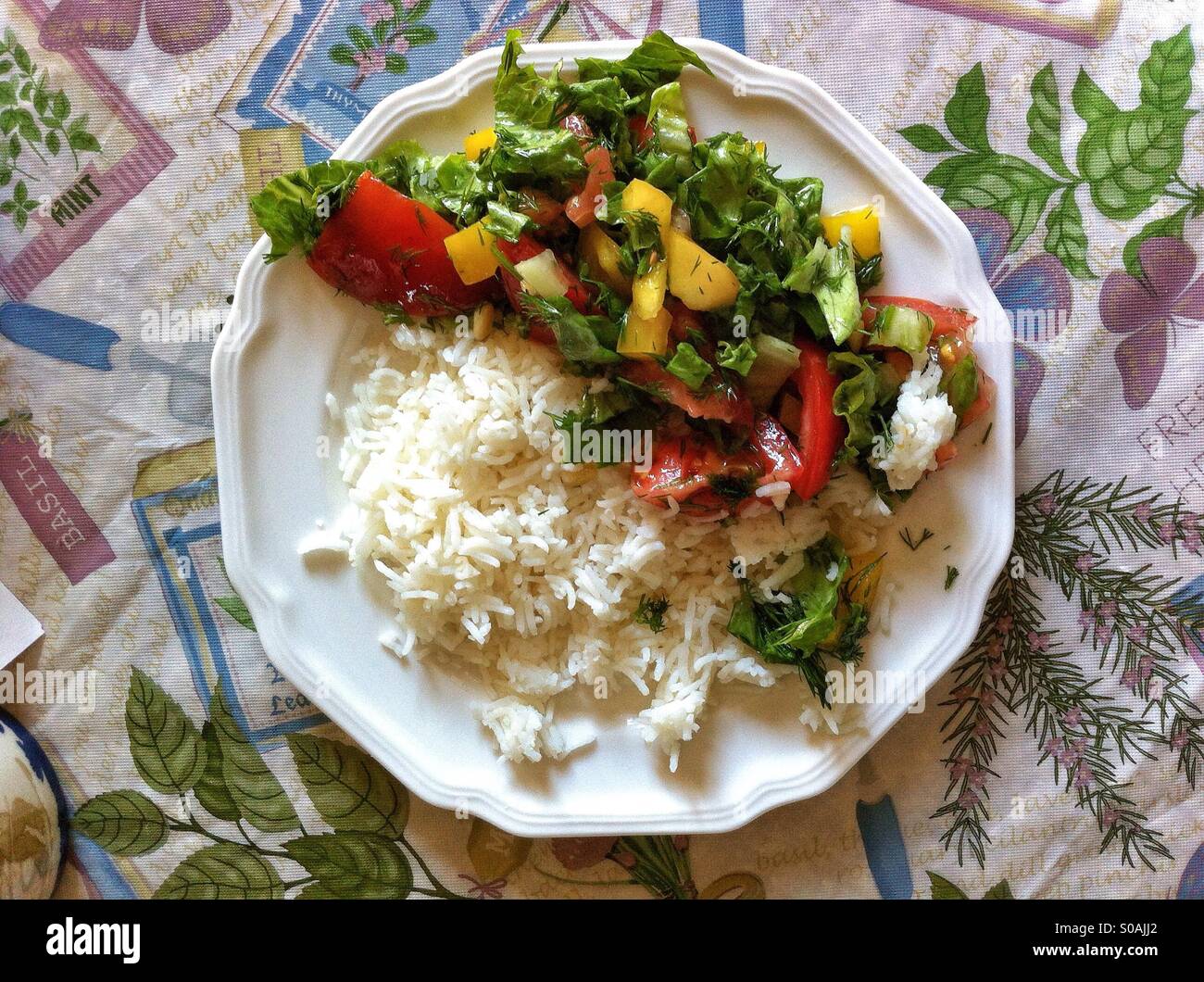 Rice and salad on a white scalloped plate Stock Photo