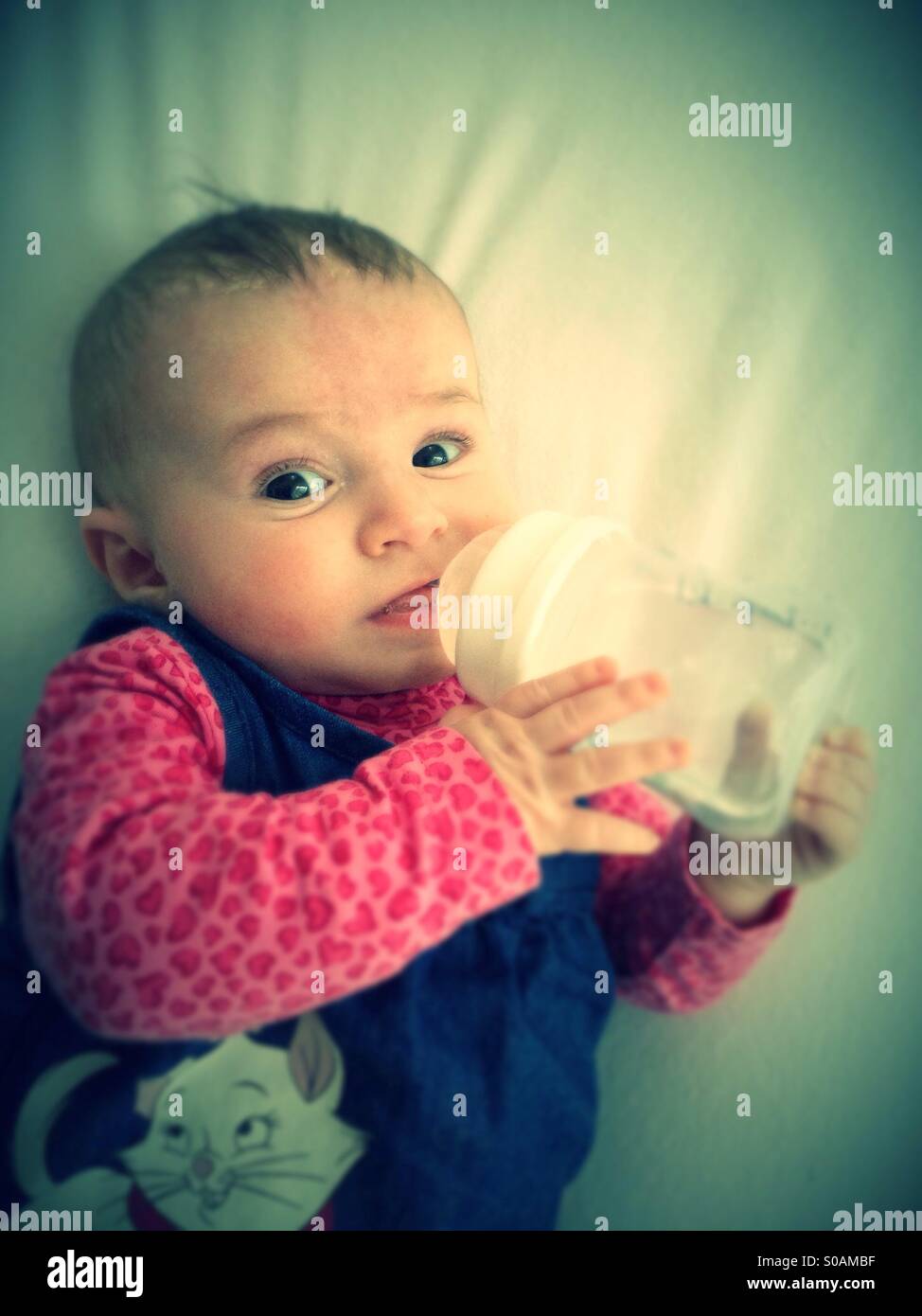 Baby drinking from baby bottle - Smartphone Captured Stock Image