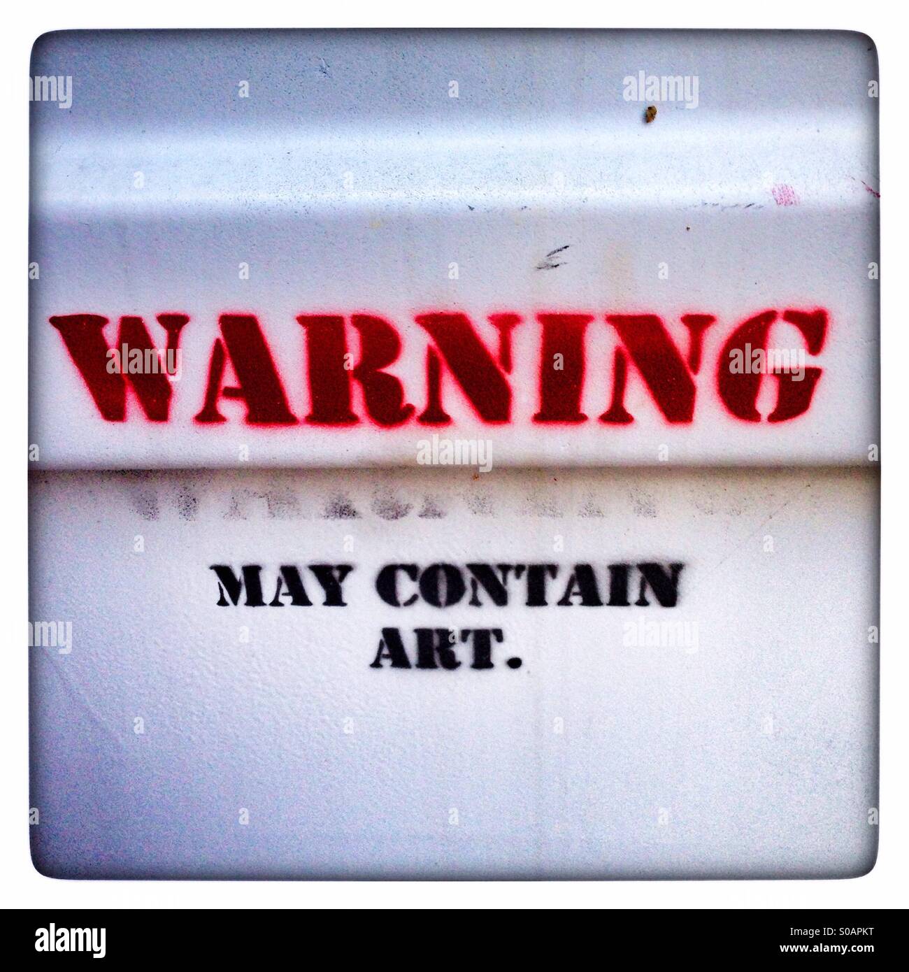 Warning may contain art graffiti stencilled on a metal door Stock Photo