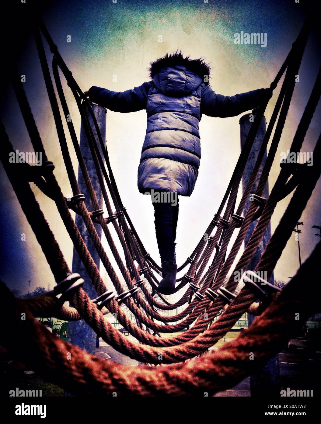 Young girl on rope bridge climbing frame Stock Photo Alamy