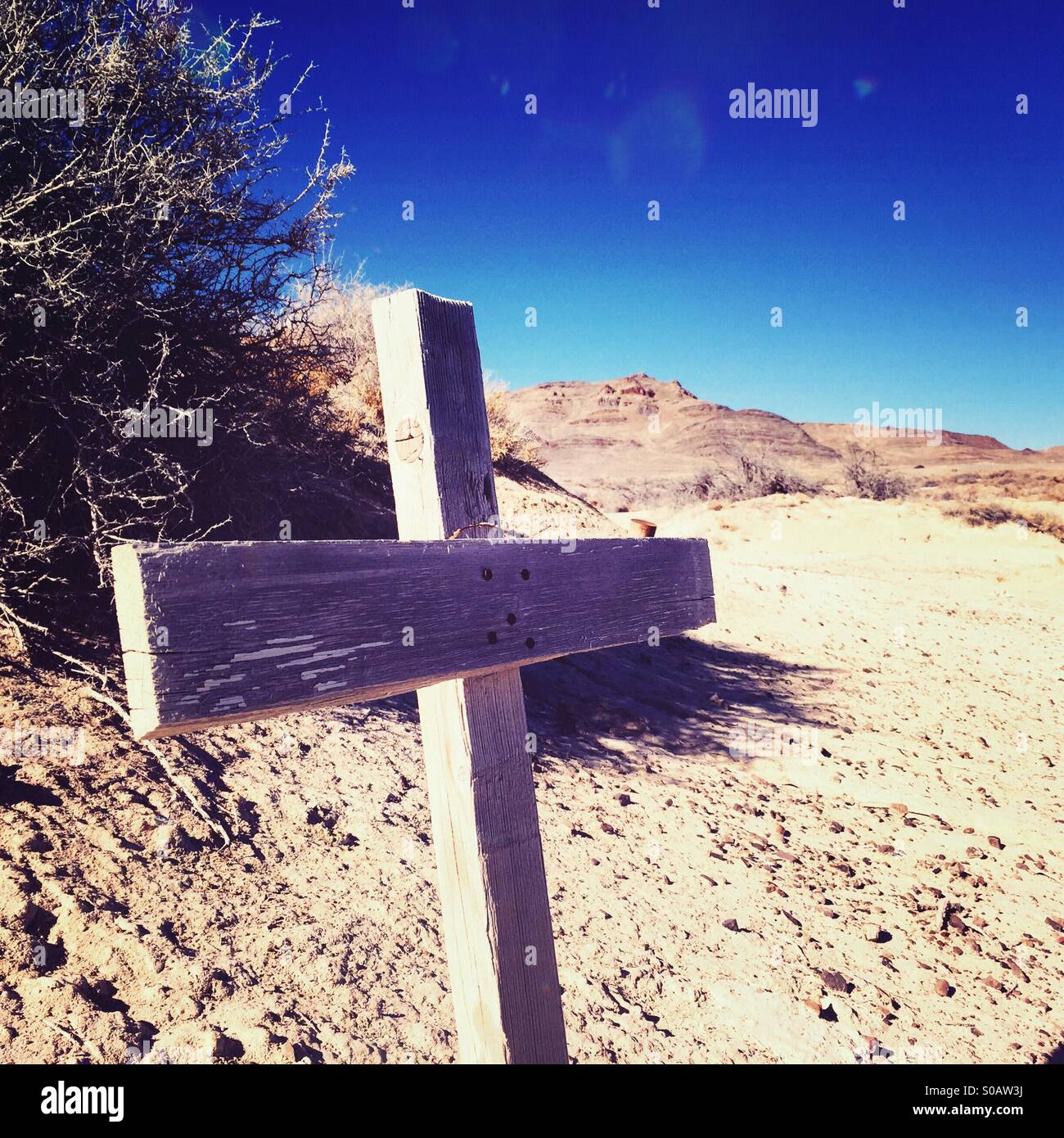 A wooden cross stands crookedly in the western Utah desert. Stock Photo