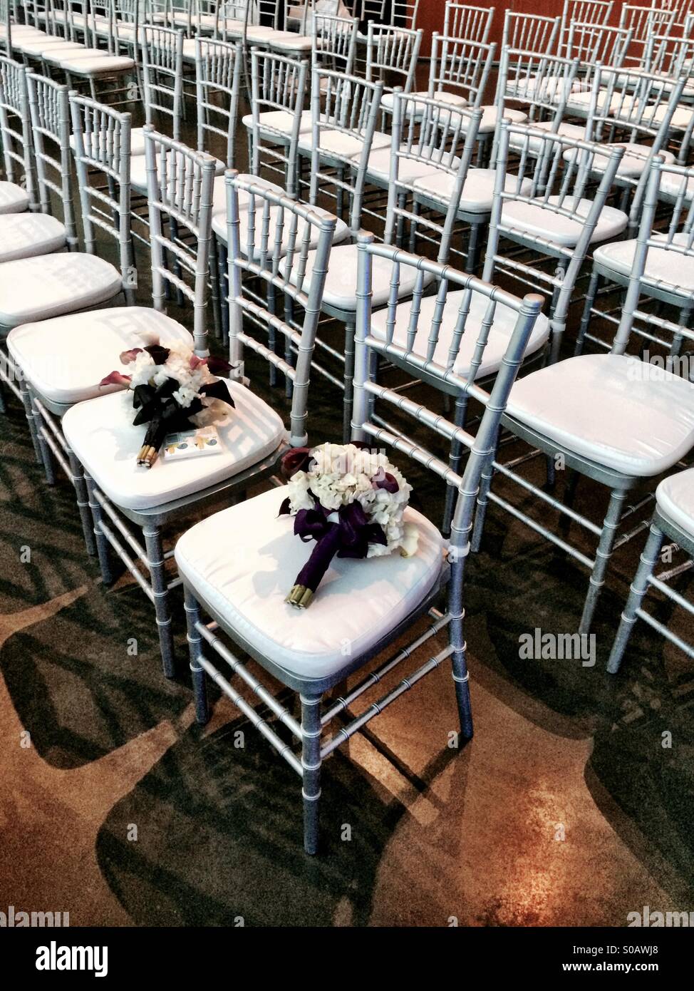 Wedding bouquets on chairs at wedding ceremony. Stock Photo