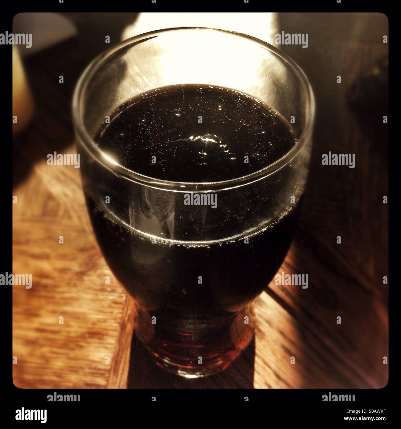 Large glass of cola on a wooden table - Smartphone Captured Stock Image