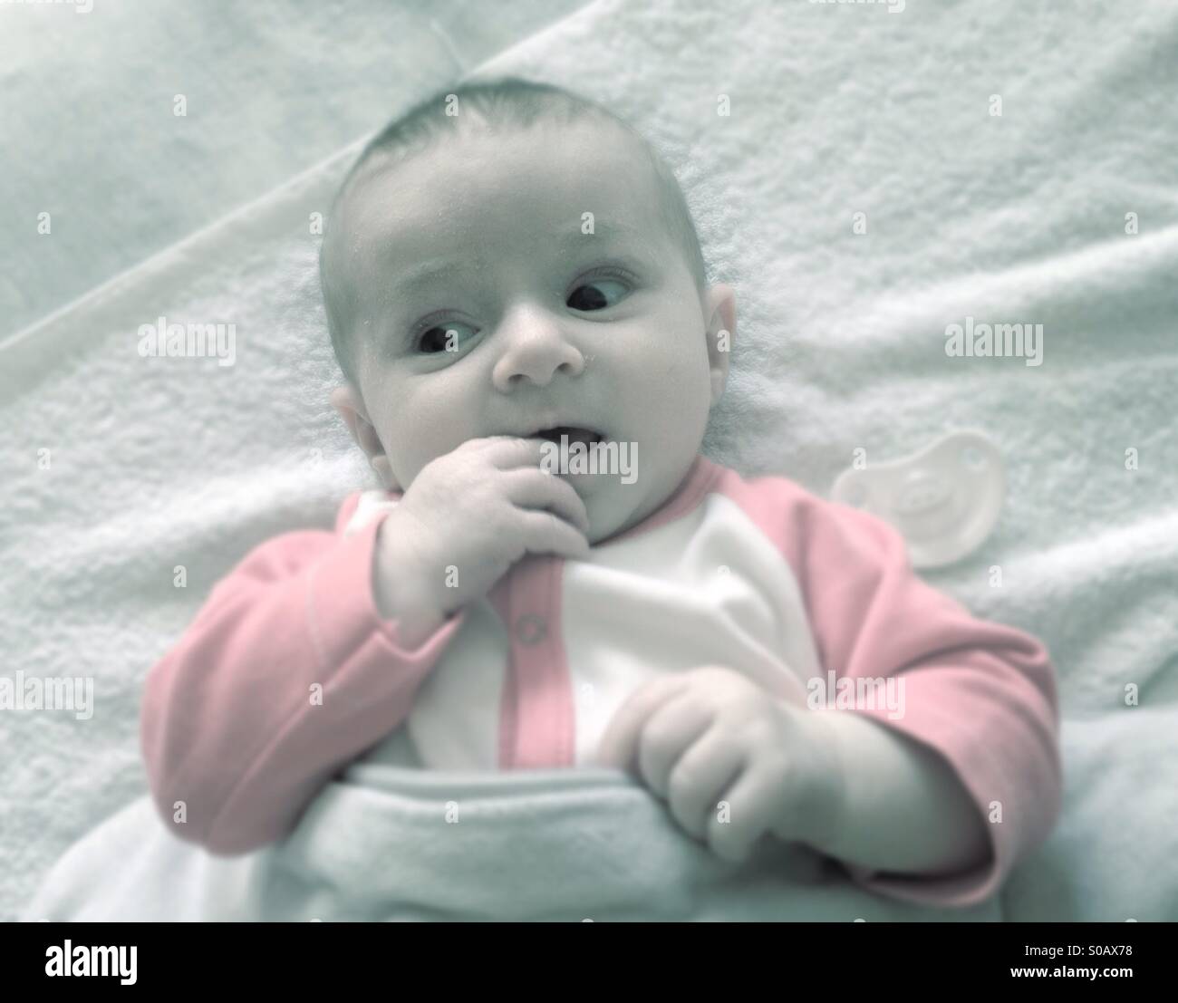 Baby lying with finger in the month - Smartphone Captured Stock Image