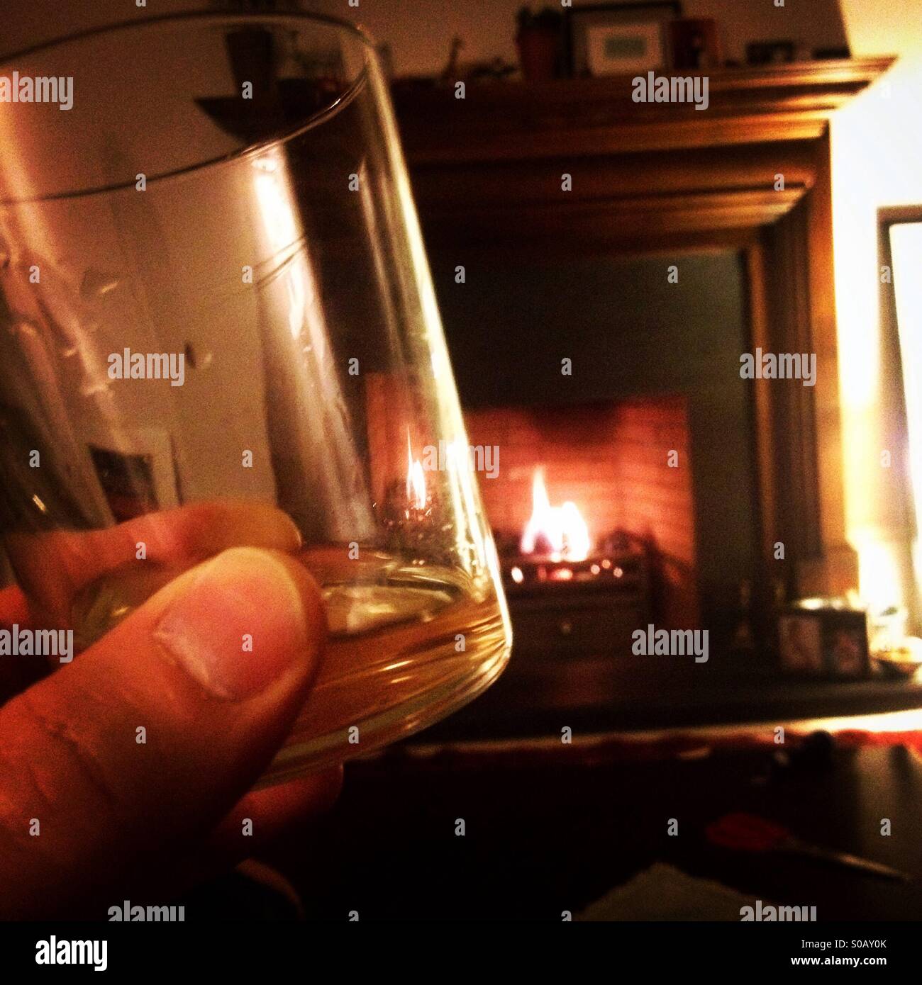 Drinking whisky beside the fire Stock Photo