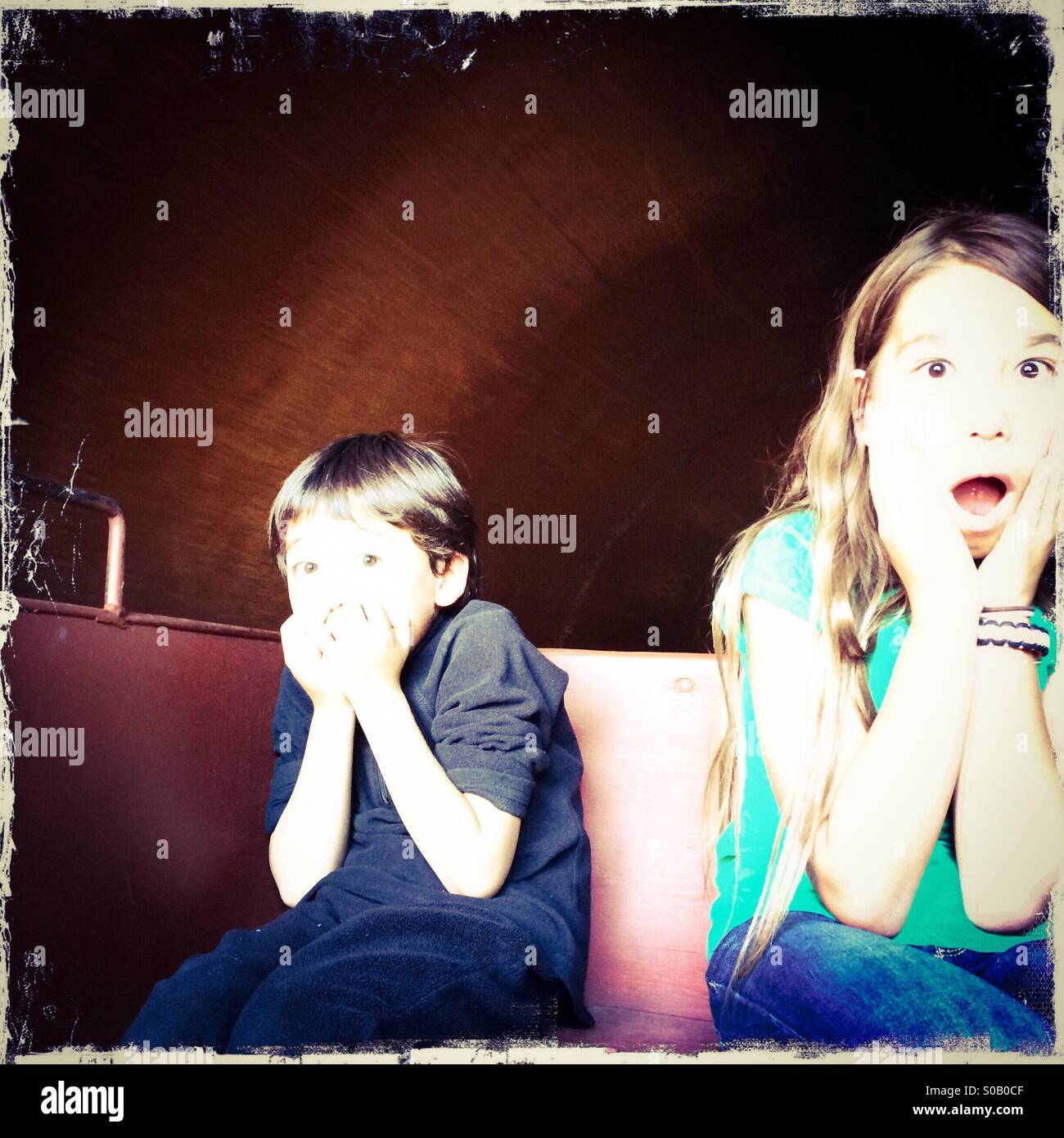 A ten year old girl and her five year old brother come out of a dark train tunnel scared. - Smartphone Captured Stock Image