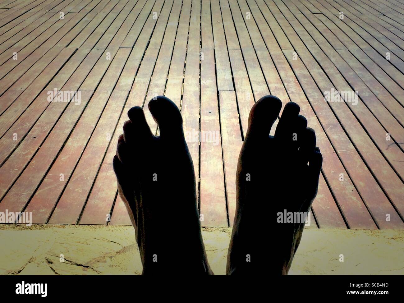 Silhouette of feet against deck Stock Photo