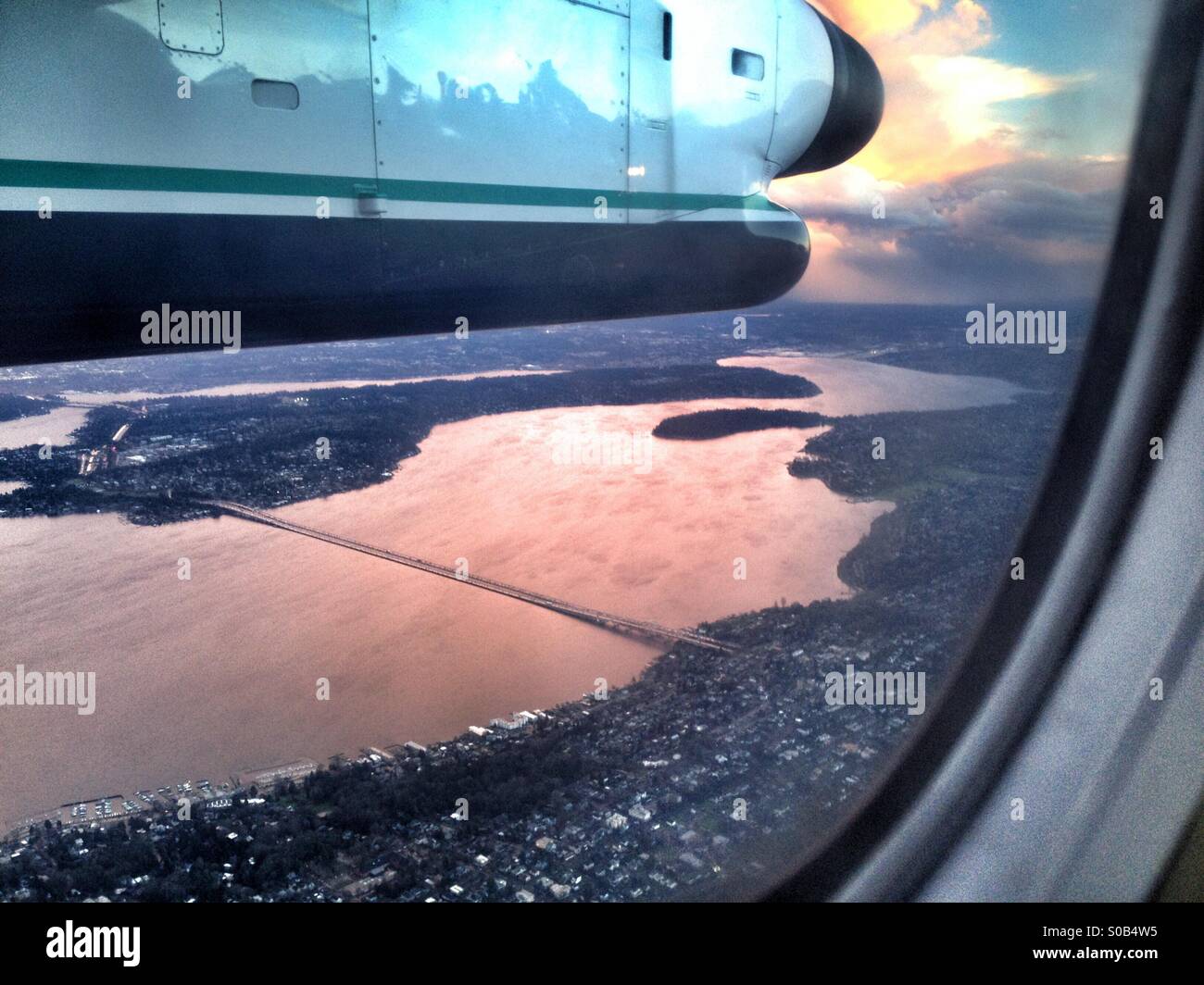 Looking out a plane's window, overlooking Seattle and Puget Sound at sunset. - Smartphone Captured Stock Image