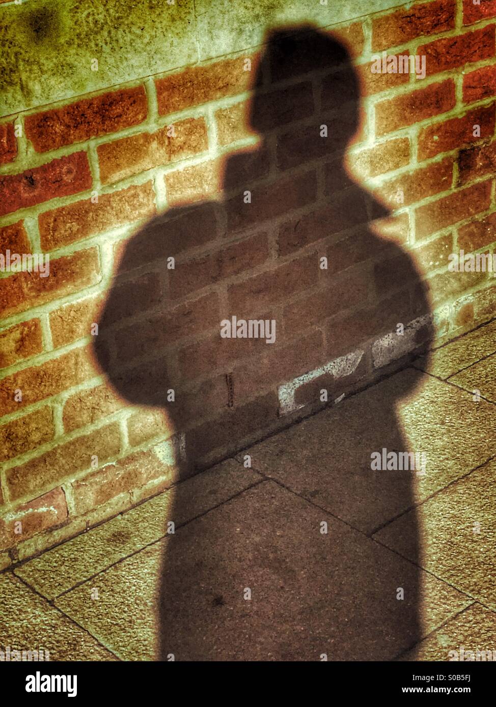 Silhouette of a man on a wall - Smartphone Captured Stock Image